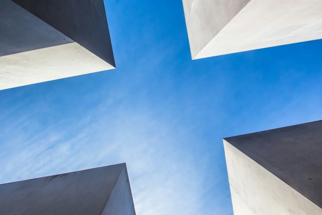 Four concrete structures framing a cross-shaped opening to the sky